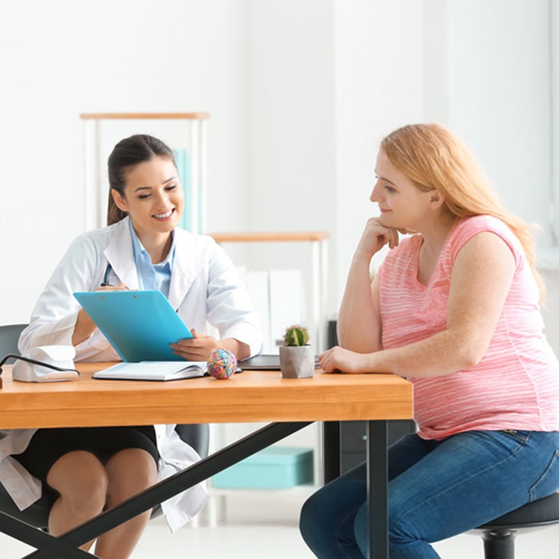 Doctor consulting with patient about weight loss options in a medical office setting.